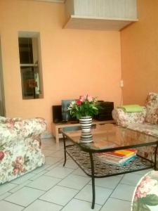 a living room with a table with a vase of flowers at Ferienwohnung Mosel-Rhein in Koblenz