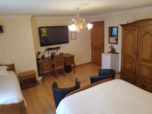 a bedroom with a bed and a desk and a tv at Chavot Bellevue in Chavot-Courcourt