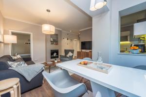 a kitchen and living room with a couch and a table at Sunset Beach Apartment in Zadar