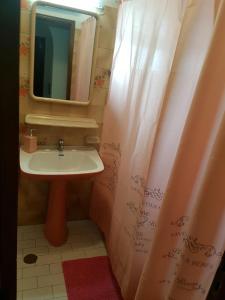 a bathroom with a sink and a mirror and a shower curtain at Apartamento Fuseta in Fuzeta