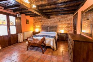 San Esteban de la Sierraにあるcasa rural la tramoneraのベッドルーム1室(ベッド1台、椅子1脚付)