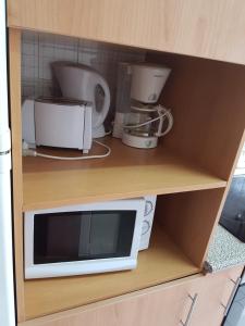 a microwave and other appliances sitting on a shelf at Apartamento Fuseta in Fuzeta