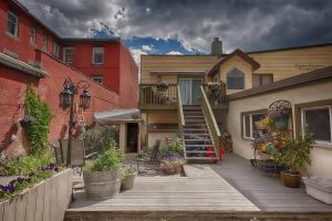 una casa con una terraza de madera con flores y escaleras en Country Encounters Accommodations en Coleman