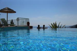 two people laying in the water in a swimming pool at Residenza l 'Alivetu in Cargèse