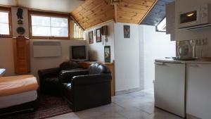 a living room with two chairs and a kitchen at Pension Karolína in Trnava