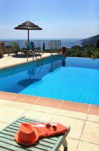 a hat sitting on a bench next to a swimming pool at Residenza l 'Alivetu in Cargèse