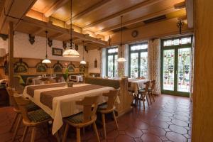 a dining room with tables and chairs and windows at Hotel am Schloss in Illertissen