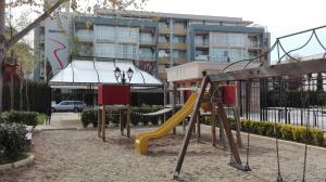een speeltuin met een glijbaan voor een gebouw bij Sun City Apartments in Sunny Beach