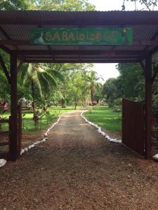 een poort met een bord waarop staat: Santa baala lodge bij Sabalo Lodge Tours and Cabins in Sierpe