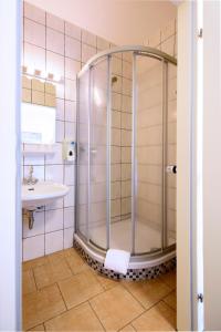 ein Bad mit einer Dusche und einem Waschbecken in der Unterkunft Best Deal Airporthotel Weeze in Weeze