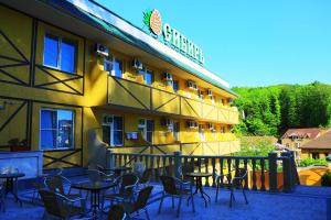 un restaurante con mesas y sillas fuera de un edificio en Sibir Mini-hotel, en Adler