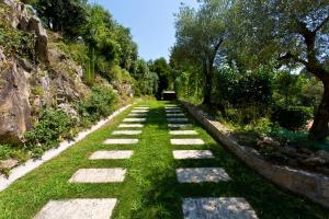a stone pathway in a park with grass and trees at Casa da Beira Rio - Country side Vacation home in Touguinho
