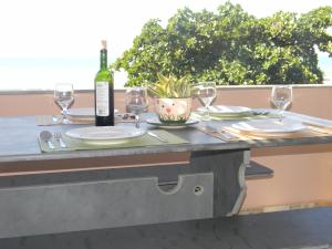 una mesa con copas y una botella de vino en CocoBeachNat 5A, en Natal