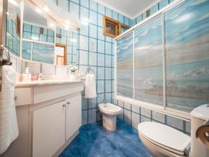 ein blau gefliestes Badezimmer mit Toilette und Waschbecken in der Unterkunft Bunyola in Bunyola + 37 Fotos