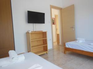 a room with two beds and a flat screen tv at Apartments Monika in Kriopigi