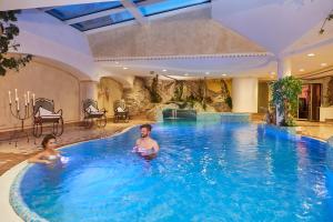 a man and a woman in a swimming pool at Hotel Mühlgarten in San Lorenzo di Sebato