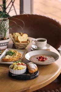 una mesa con platos de comida y una taza de café en Hotel Pelican, en Krasnodar