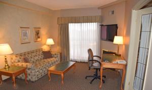 a hotel room with a couch and a living room at Stone Gate Inn in Orillia