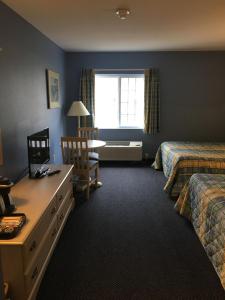 a hotel room with two beds and a desk and a window at South Beach Resort Hotel in Marblehead