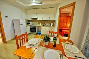 uma cozinha com uma mesa de madeira com cadeiras e uma sala de jantar em Apartment Acacias em Lloret de Mar