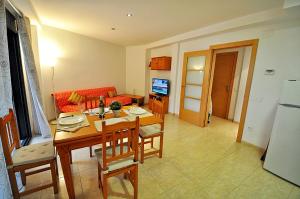 uma cozinha e sala de estar com mesa e cadeiras em Apartment Acacias em Lloret de Mar