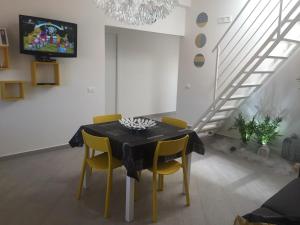 Casa Vacanze Anna في باليستراتي: غرفة طعام مع طاولة سوداء وكراسي صفراء