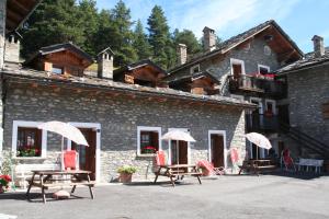 un edificio con sedie e ombrelloni di fronte di Villaggio Gerbore a Saint Nicolas