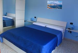 een blauwe slaapkamer met een bed met een blauwe deken bij B&B La Panoramica in Casola di Napoli
