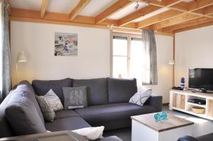a living room with a couch and a tv at Zeepark Mercator in Wenduine