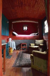 uma sala de estar com uma cama na parede em Gipsy Caravan em Ittre