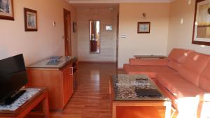 a living room with a couch and a tv at Hotel Rusadir in Melilla