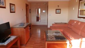 - un salon avec un canapé et une télévision dans l'établissement Hotel Rusadir, à Melilla