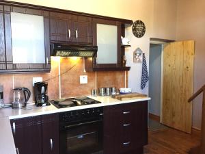 a kitchen with wooden cabinets and a stove top oven at Sea View Charming Stone House in Mossel Bay