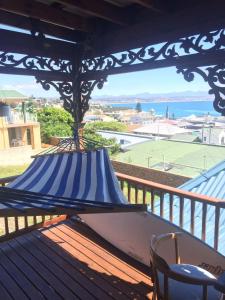 a hammock on a deck with a view of the ocean at Sea View Charming Stone House in Mossel Bay