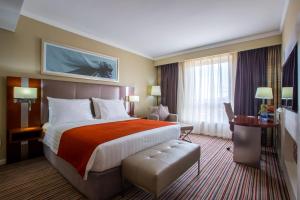 a hotel room with a large bed and a desk at Park Inn by Radisson, Kigali in Kigali +92 photos