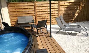 a hot tub in a backyard with chairs and a table at LOFT SPA - Côté château. in Carcassonne