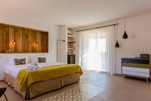 a bedroom with a large bed with a yellow blanket at Hotel Les Chambres de Mila Bonifacio in Bonifacio