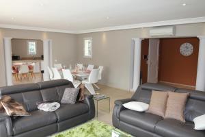 a living room with two couches and a dining room at Villa Jasmin Regusse in Régusse