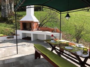 a patio with a table and a brick oven at Kuća Pink in Mrzla Vodica