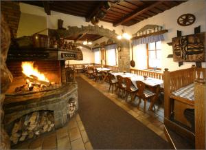 a restaurant with a fireplace and tables and chairs at Valašský Šenk in Vizovice