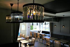 une salle à manger avec des tables et des chaises sous un lustre dans l'établissement Sadama street Villa, à Pärnu