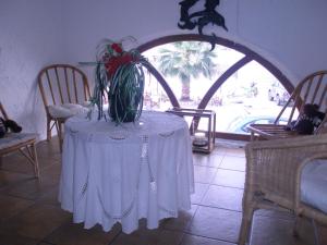 a table with a white table cloth and a plant on it at Captain's House Hotel in Skala