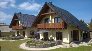 a house with a black roof and a balcony at Ferienhaus Leo und Livia in Zempin