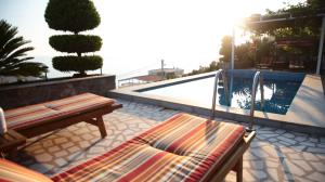 a patio with two benches and a swimming pool at Apartments Bardak in Dobra Voda