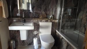 a bathroom with a sink, toilet, and bathtub at Star Inn Rooms in Ardersier