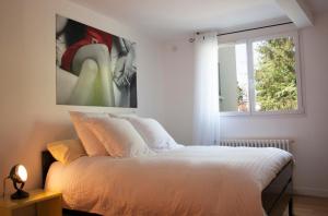 En eller flere senger på et rom på Une chambre à Neuilly Guest house