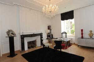 a living room with a table and a chandelier at Hôtel Victor Hugo in Pontorson