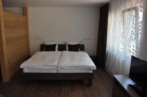 een slaapkamer met een bed en een flatscreen-tv bij Alte Bäckerei in Schwarzsee