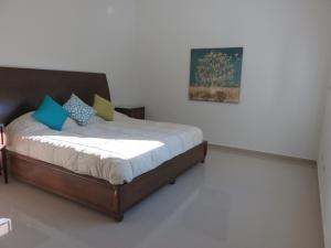 una camera da letto con un letto e un dipinto sul muro di Apartamento en la playa en Mazatlán a Mazatlán