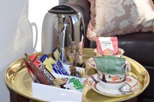 a gold table with a tray with a tea set on it at The Highlandman Station in Crieff